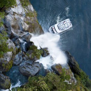 New Zealand Milford Sounds Tours.Nature-Cruise-Spirit-of-Milford-under-Waterfall-from-Above-screen